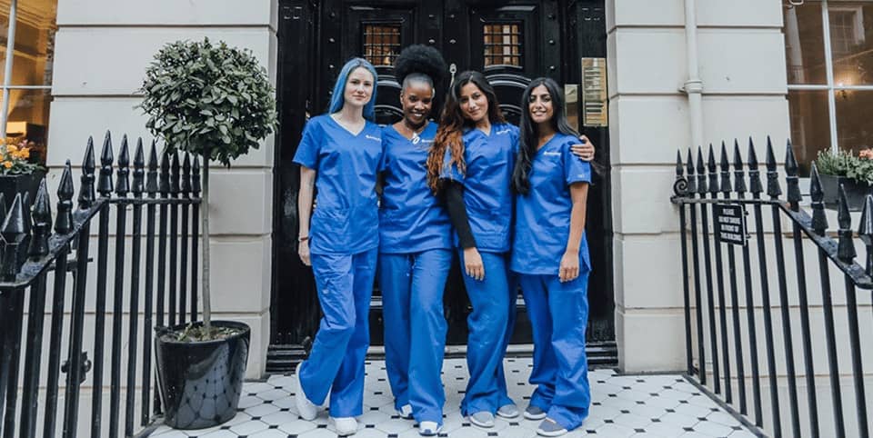 Four nurses in blue scrubs outside a Georgian clinic entrance, PicoSure Pro laser treatment London